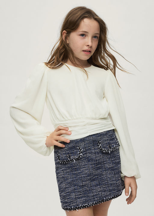 Girl wearing Mayoral cream balloon sleeve pleated blouse styled with navy tweed skirt