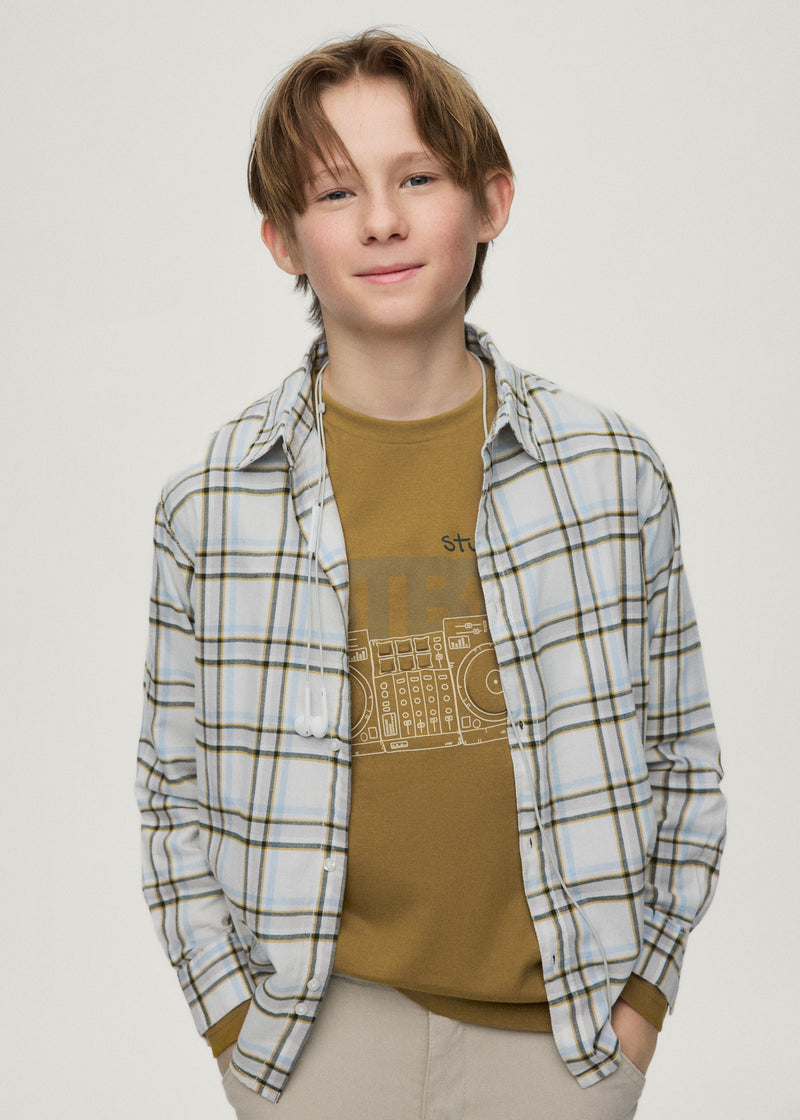 Boy wearing Mayoral Nukutavake check shirt open over olive graphic tee – on model front view