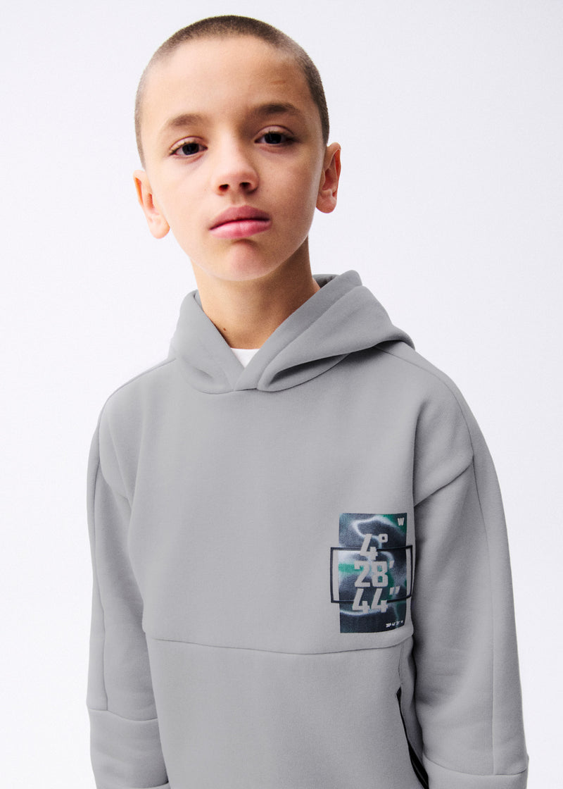 Boy wearing Mayoral Nukutavake tech coordinates hoodie – on model front portrait showing chest patch
