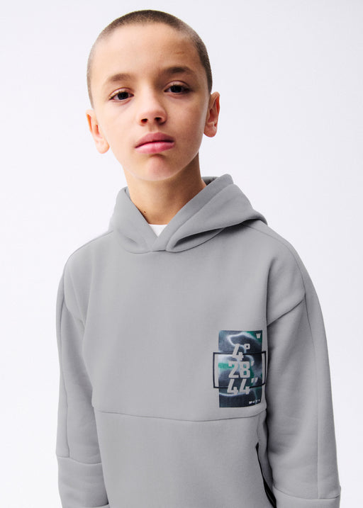 Boy wearing Mayoral Nukutavake tech coordinates hoodie – on model front portrait showing chest patch