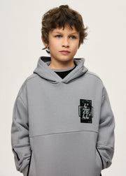 Boy wearing Mayoral Nukutavake tech hoodie – close-up showing coordinates chest patch and zip pocket detail