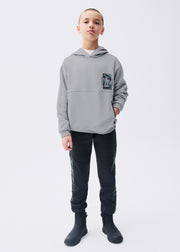 Boy wearing Mayoral Nukutavake black camo side panel joggers with matching black hoodie holding basketball – on model full body front view