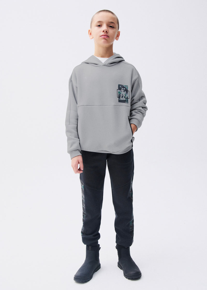 Boy wearing Mayoral Nukutavake black camo side panel joggers with matching black hoodie holding basketball – on model full body front view
