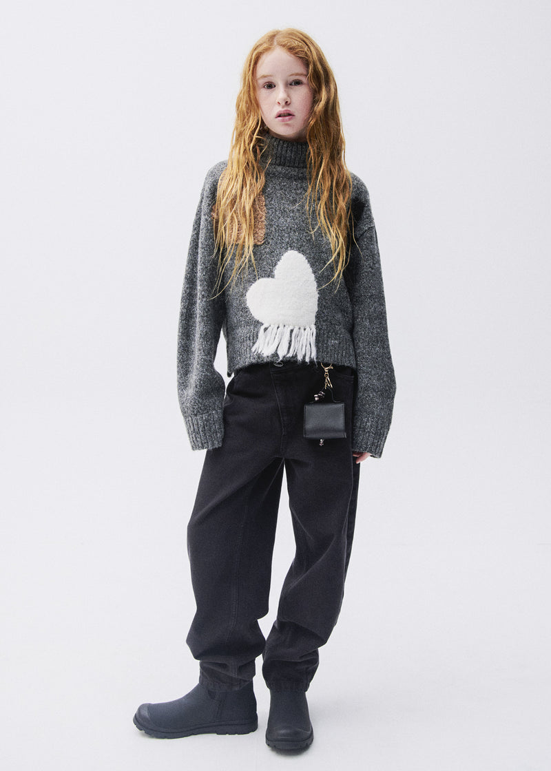 Girl wearing Mayoral black barrel-leg jeans with grey turtleneck heart knit and black boots – on model full body front view