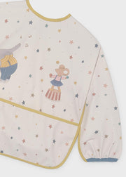 Mayoral baby circus star long-sleeve smock bib – front flat lay showing full star print, mustard piping, circus appliqué and front pocket